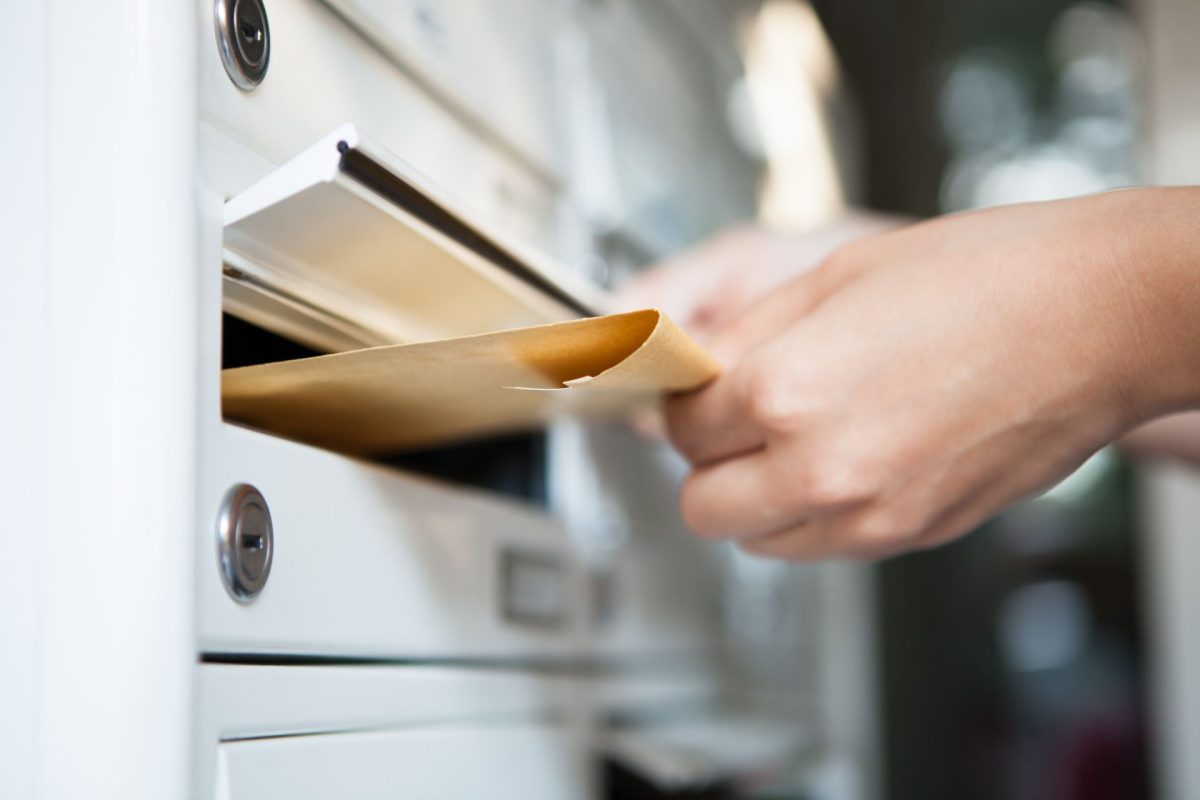 Close-up,Of,Woman's,Hand,Holding,Envelope,And,Inserting,In,Mailbox